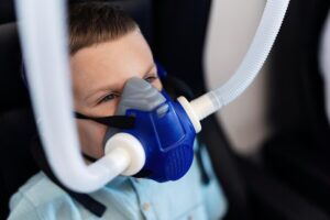 small-kid-breathing-through-oxygen-mask-while-having-therapy-hyperbaric-chambe